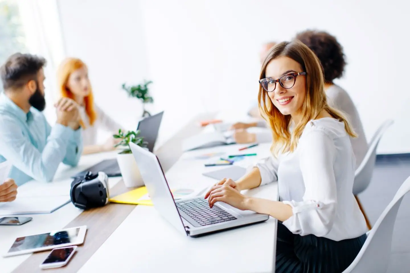 Funcionária sorridente da T-Systems com laptop