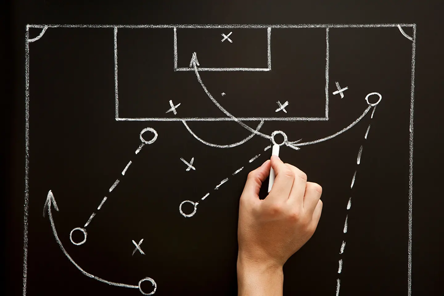 Um técnico elabora uma estratégia para uma partida de futebol no vestiário.