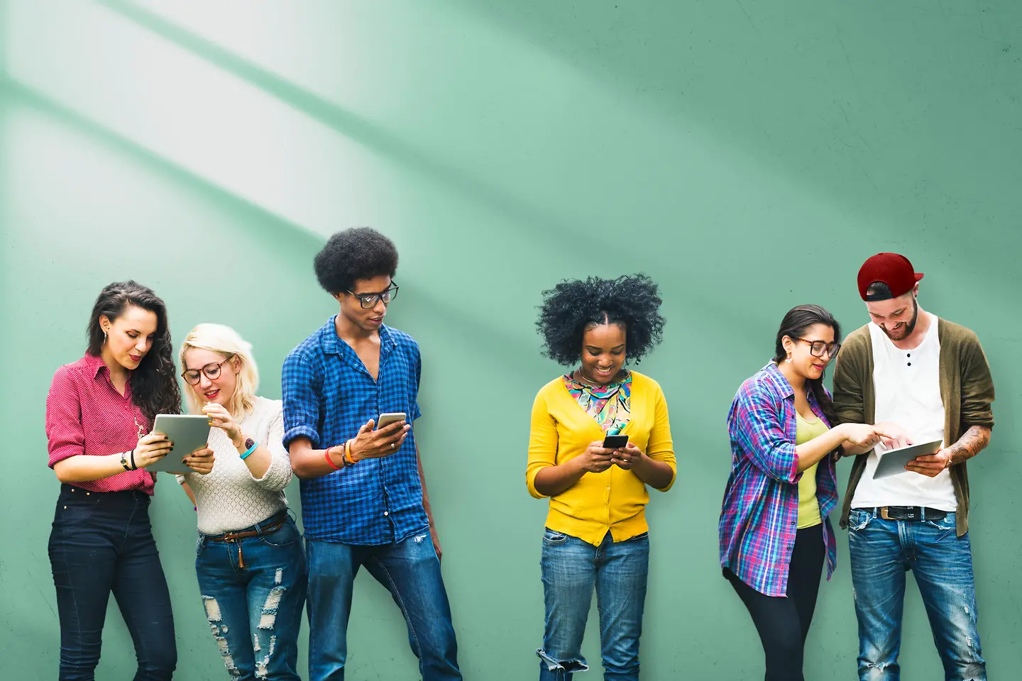 Grupo de jóvenes con tabletas, teléfonos móviles y ordenadores portátiles