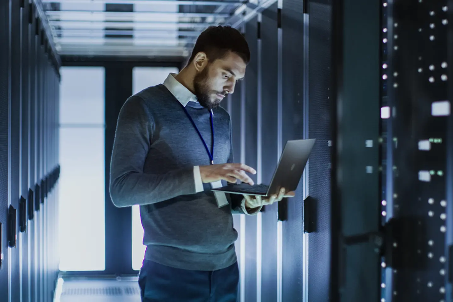 An IT-person checking his laptop in the server-room