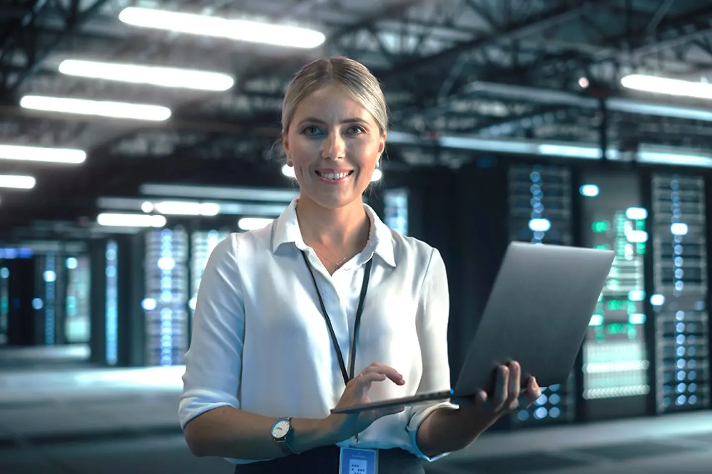 Una experta en cloud revisando datos en un portátil en el centro de datos