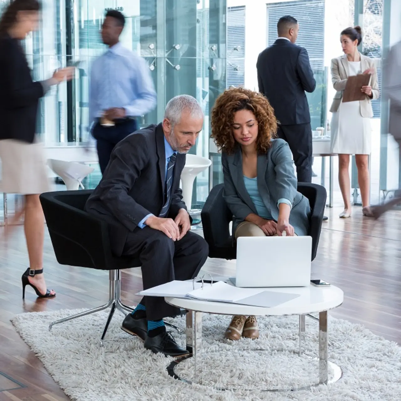 Des hommes d’affaires discutent de la transformation des données à une table sur laquelle est posé un ordinateur portable.