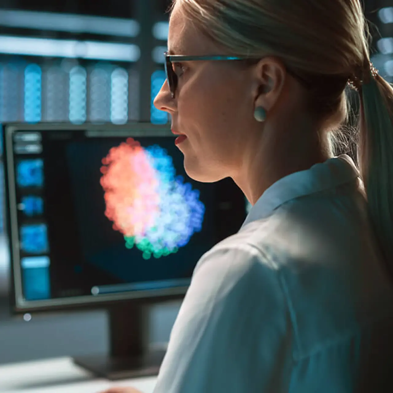 IT-Spezialistin arbeitet an Bildschirmen mit vielen Datenvisualisierungen - Quantencomputer